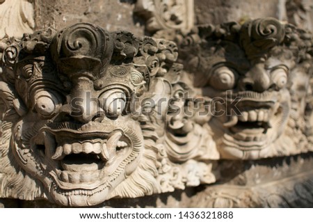 Close up picture of two beautiful Balinese figures engraved on a wall located in Ubud, Bali - Indonesia