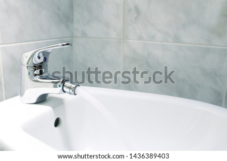Detail of the faucet of a bidet with running water.The bidet was invented in France in the 1700s