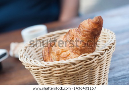 Closeup of traditional croissant in a wooden basket  on wooden table
