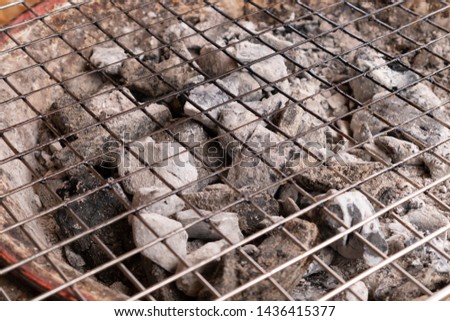 The charcoal is burned in the stove. Steel grating on the stove.