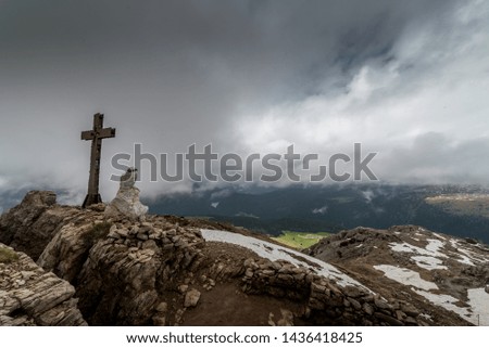 A cross and a statue standing on the top of mountain