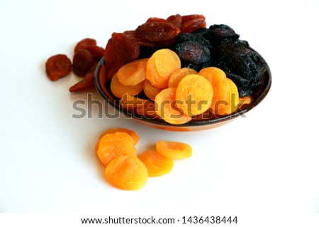 Mix of dried fruits in bowl on white background Royalty-Free Stock Photo #1436438444
