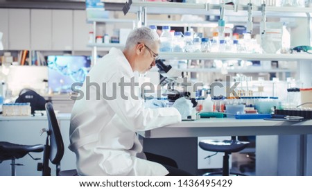 Senior Male Research Scientist is Working with Electron Microscope in a Modern High-Tech Laboratory. Genetics and Pharmaceutical Studies and Researches.