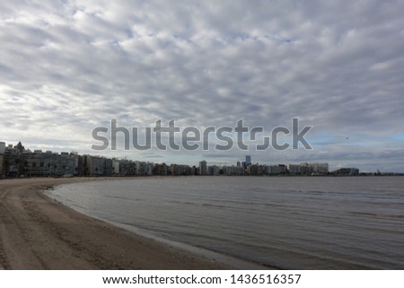 Montevideo/Uruguay-6/1/19: The sand beach with a view of the skyline and water at the La Rambla on a beautiful sunny winter day in Montevideo, Uruguay.