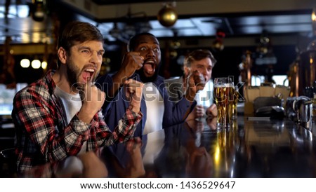 Joyful multiracial friends cheering for favorite team in bar, celebrating goal Royalty-Free Stock Photo #1436529647