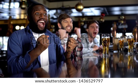 Emotional african-american male celebrating favorite team victory, rest in bar Royalty-Free Stock Photo #1436529797