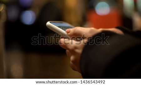 Female hands scrolling pictures on smartphone, using photo editor, application