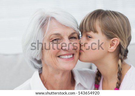 Portrait of a cute little girl kissing her grandmother