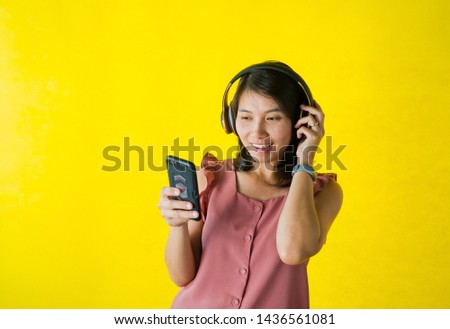 woman playing smartphone on yellow background, typing phone and sending message, business concept and online shopping
