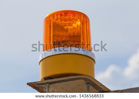 Orange flashing and revolving light on sky background