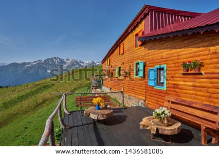 Colorful traditional wooden plateau house, green nature and snowy mountains. Photo was taken at Gito Plateau, Rize, northeastern Karadeniz (Black Sea) region of Turkey