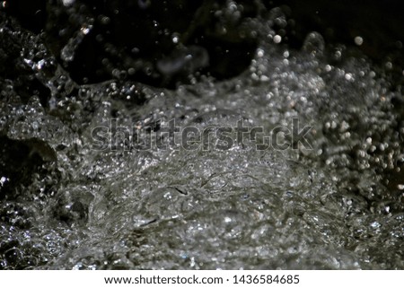 Abstract stand still water spread and splash on a black texture background.
