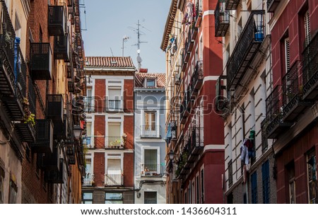 Exterior view of beautiful historical buildings in Central Madrid, Spain, Europe. Colorful Mediterranean street scene in the Lavapiés, Embajadores neighborhood of the Spanish capital. Royalty-Free Stock Photo #1436604311