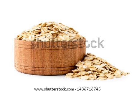 Oatmeal in a wooden plate close-up on a white background.