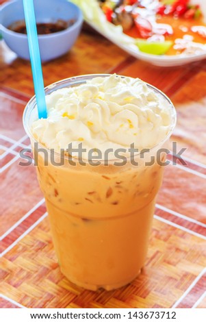 Iced coffee in take away cup on tablecloth.