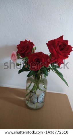 bouquet of multicolored roses on a white background in a glass vase