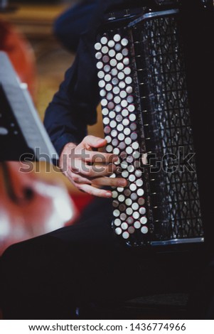 The musician plays the accordion close-up