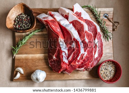 Organic grass-fed ribeye steak on wood board, paper background species. Beef Meat, raw meat. Canadian organic ribeye steak with an amazing taste. Ribeye is GMO, Steroid, Hormone and Antibiotic Free  Royalty-Free Stock Photo #1436799881