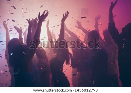 Photo of many birthday event people dancing colorful lights confetti flying enjoy nightclub hands raised up wear shiny clothes