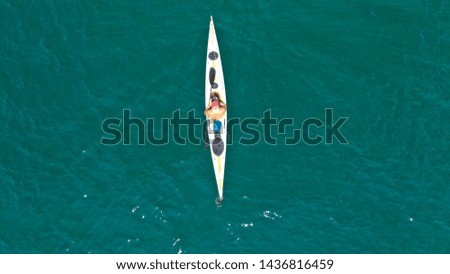 Aerial drone photo of fit man practising sport canoe in calm water sea