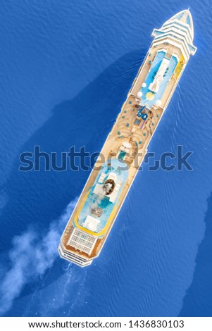 Luxury cruise ship sailing across the sea. Aerial top view at sunny day