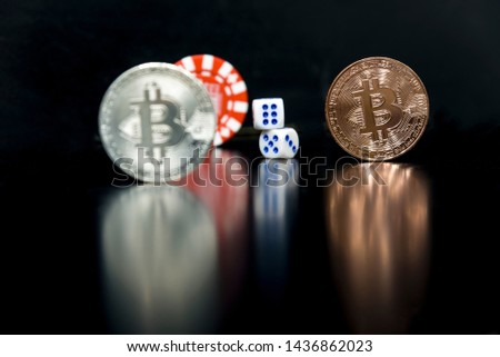 Bitcoins on a black background with game cubes.