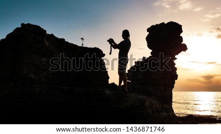 Tourist man taking pictures of amazing sea landscape at sunset time on photo camera.