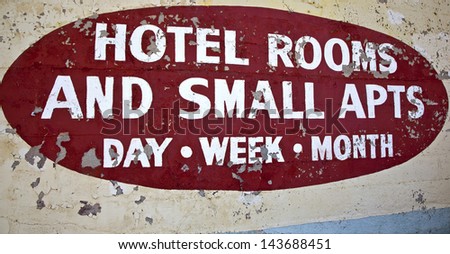Aged hotel and apartment sign peeling off wall