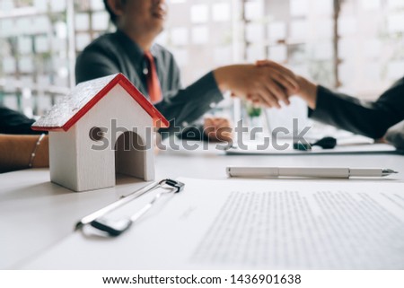 Real estate agents handshake with customers after selling houses, real estate concept.

