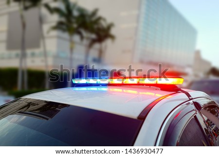 First responder police car cruiser, flashing a full array of blue and red tactical lights against a bokeh roadblock and checkpoint looking for drivers under the influence of liquors or illegal drugs Royalty-Free Stock Photo #1436930477