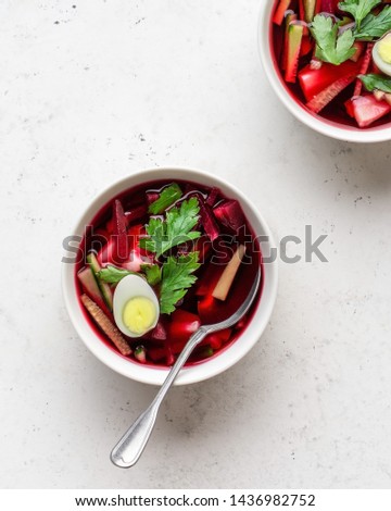 Summer cold beet soup with eggs, cucumber, potatoes and greens. White stone background. Top view.