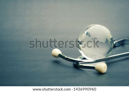 close up glass global and stethoscope on table, copy space background for text, earth day, world health day, medical and healthcare business technology concept Royalty-Free Stock Photo #1436990960