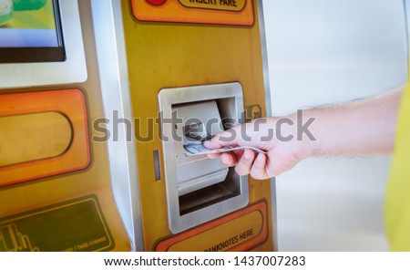 Close up man used money is purchasing a ticket at automatic machine for the Bangkok BRT, a bus rapid transit system in Bangkok, Thailand. Royalty-Free Stock Photo #1437007283