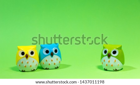 minimal creative idea concept, 2 owl doll with yellow owl doll and blue owl doll on left side and 1 green owl  right side  standing on light green background suitable for writing messages.