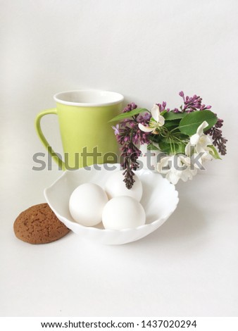 Eggs on glass plate. Breakfast good morning, beautiful food. White background color. Light green cap tea. Cookies. Bouquet spring flowers.