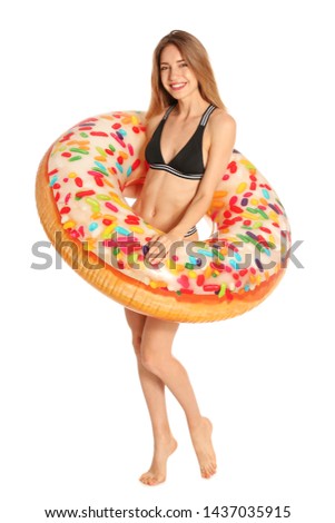 Beautiful young woman in stylish bikini with doughnut inflatable ring on white background