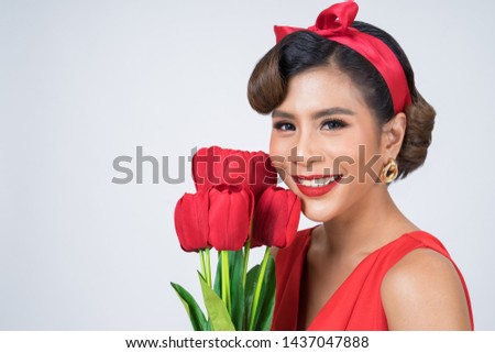 Portrait of Beautiful woman with bouquet of red tulip flowers