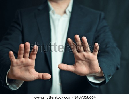 Businessman makes a defensive gesture	