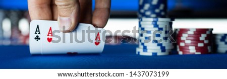 Poker tournament at casino: a player is holding two ace cards Royalty-Free Stock Photo #1437073199