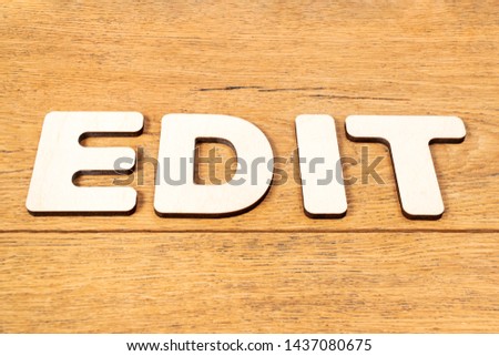 Word - edit, laid out letters on an old wooden oak table