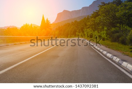 View through the windshield of cars on the highway in the mountainous area at sunrise