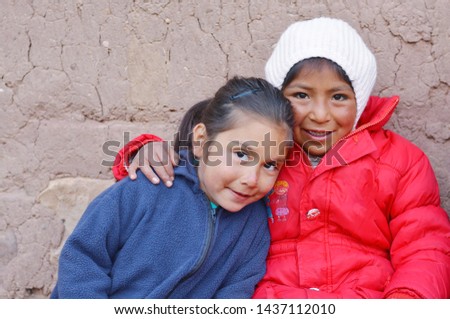 Two little girls hugging. Rural background.