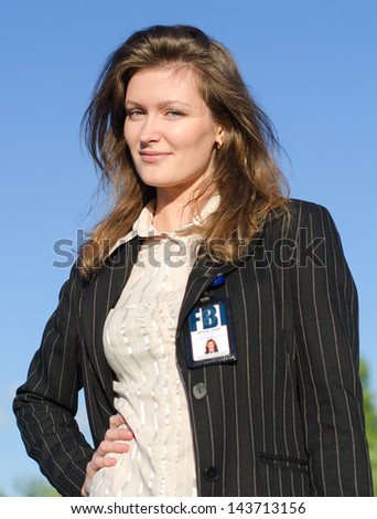 Young female criminalist on a sky background