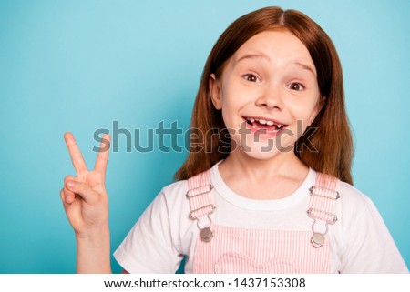Portrait of excited child make v-signs laugh laughter isolated blue background