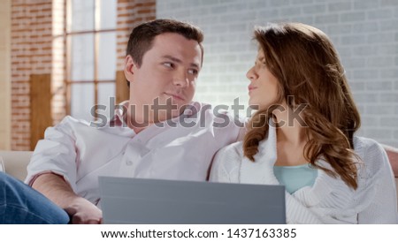 Young couple shopping on laptop, choosing vacation tour together, booking