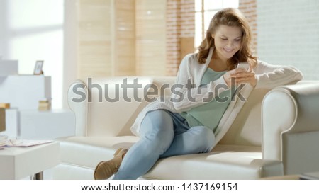 Beautiful girl typing message, chatting on smartphone in social networks at home