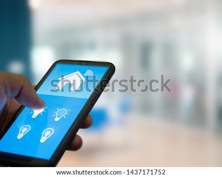Smart home automation. hands holding smartphone to control the Electrical equipment in the house. Royalty-Free Stock Photo #1437171752