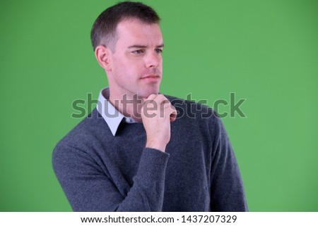 Face of businessman thinking against green background