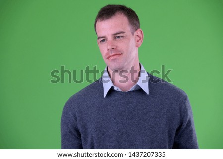 Face of businessman thinking against green background