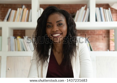 Smiling african american business woman coach teacher hr looking at camera, happy black lady making video call for online job interview by webcamera recording training webinar, webcam view, portrait Royalty-Free Stock Photo #1437231683